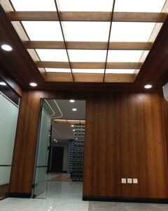 White plain stretch fabric ceiling integrated into a wooden coffer grid at corporate headquarters in Islamabad by Newon