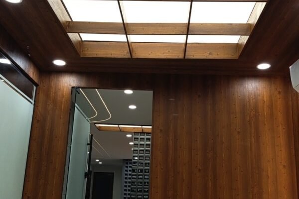 White plain stretch fabric ceiling integrated into a wooden coffer grid at corporate headquarters in Islamabad by Newon