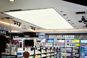 Finished 8x20 ft white plain backlit stretch fabric ceiling glowing uniformly over the Shaheen Cosmetics sales floor